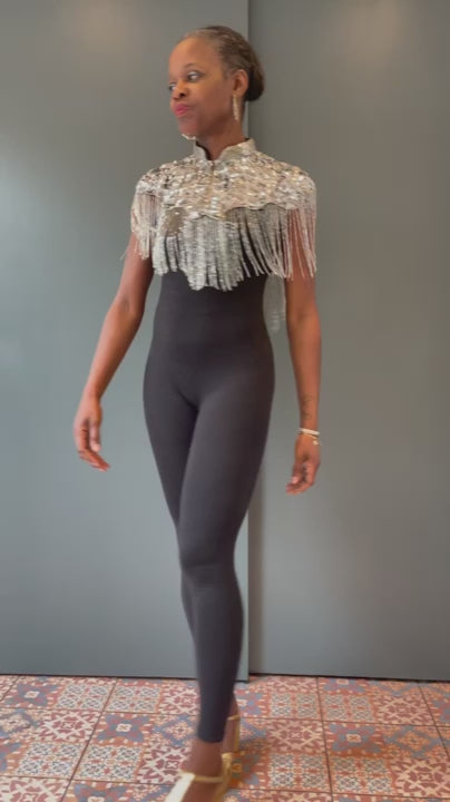 Woman wearing silver cape twirling